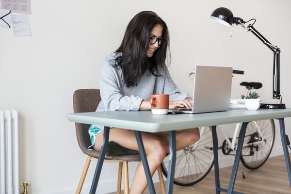 A woman sitting at a desk typing on a laptop