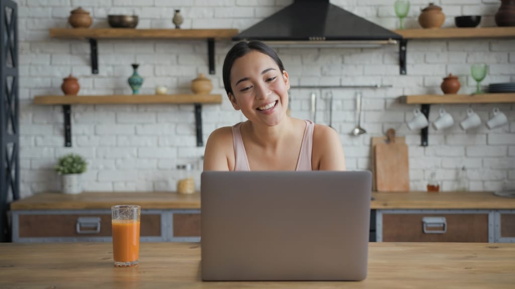 woman sitting at kitchen counter with laptop