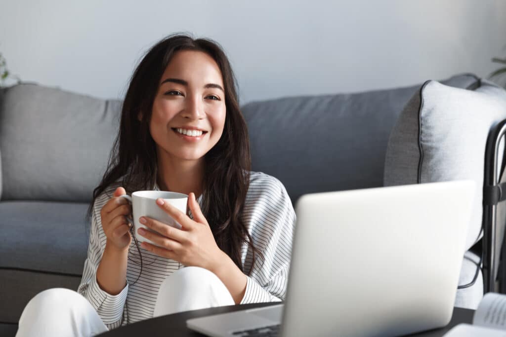 Woman in front of her laptop studying her Holistic Nutritionist Certification curriculum online