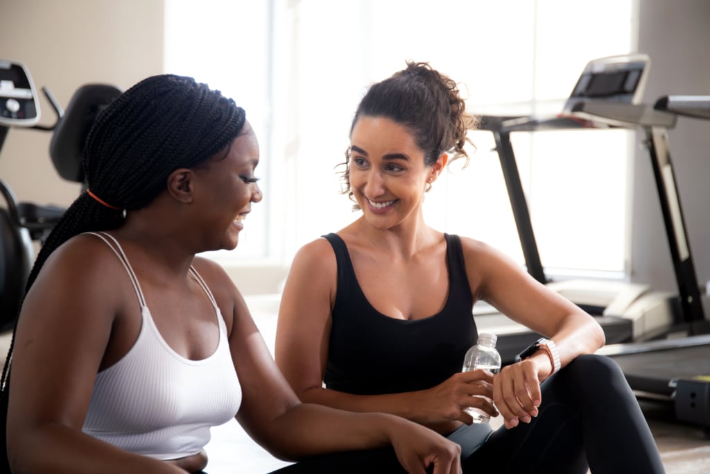 two young women talking in the gym