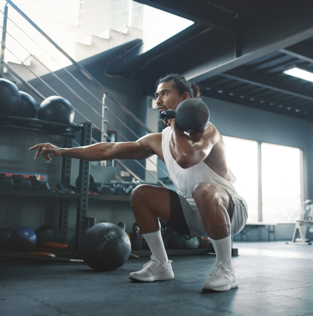 man squats with kettlebell in clean position