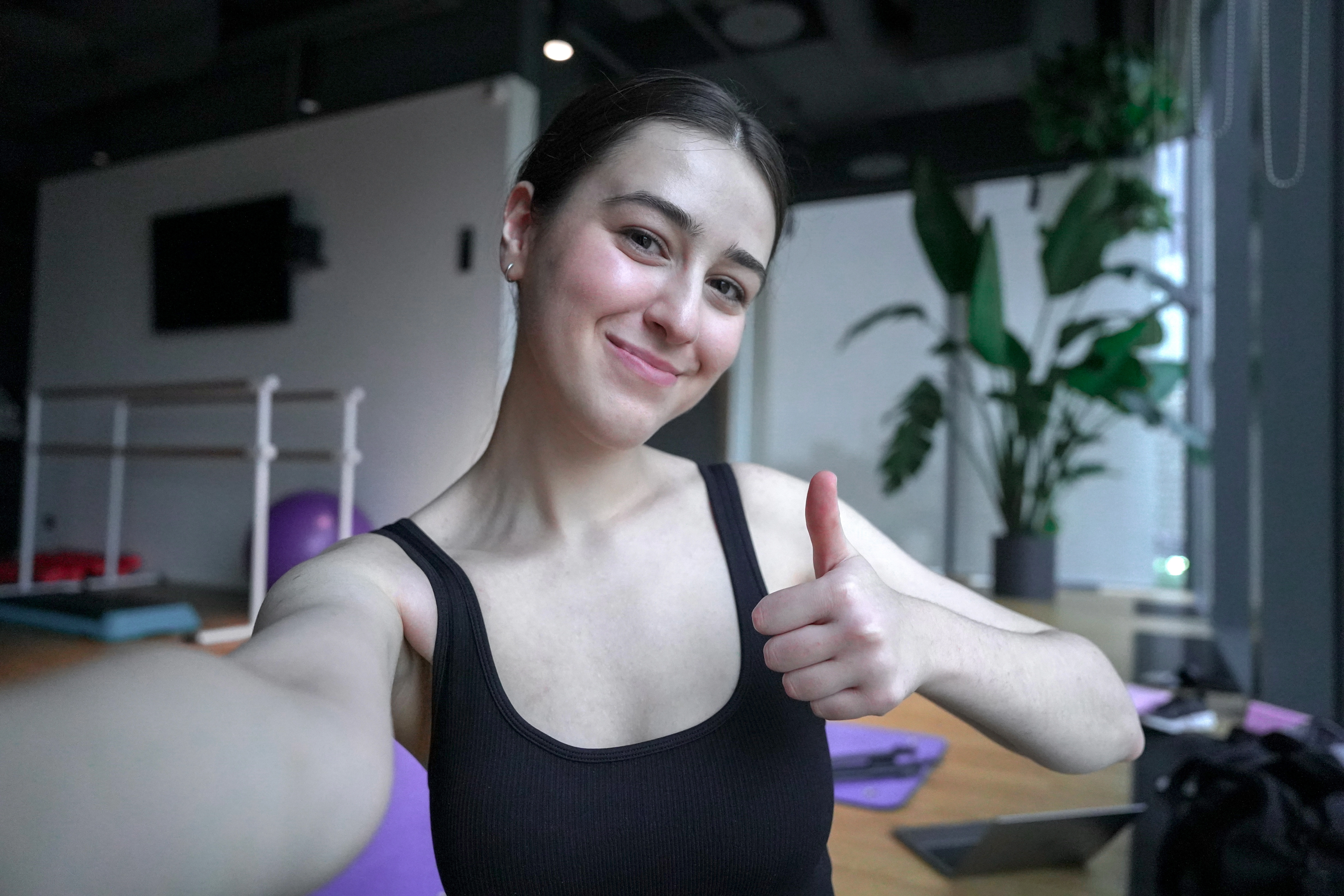 Woman with thumbs up in fitness studio