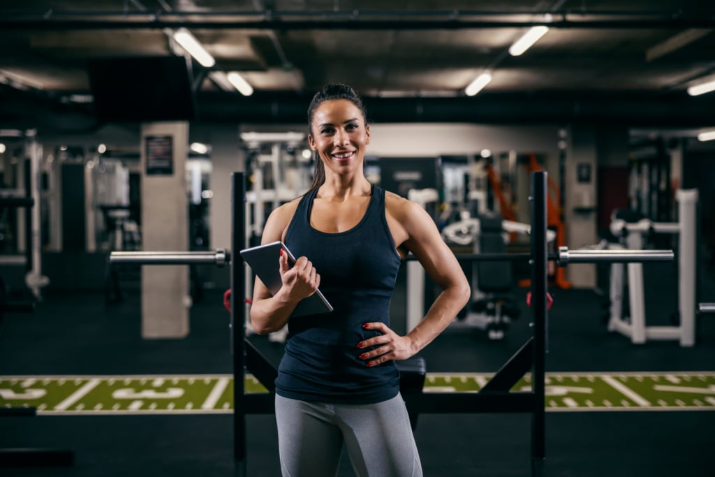 personal trainer in gym holding a tablet